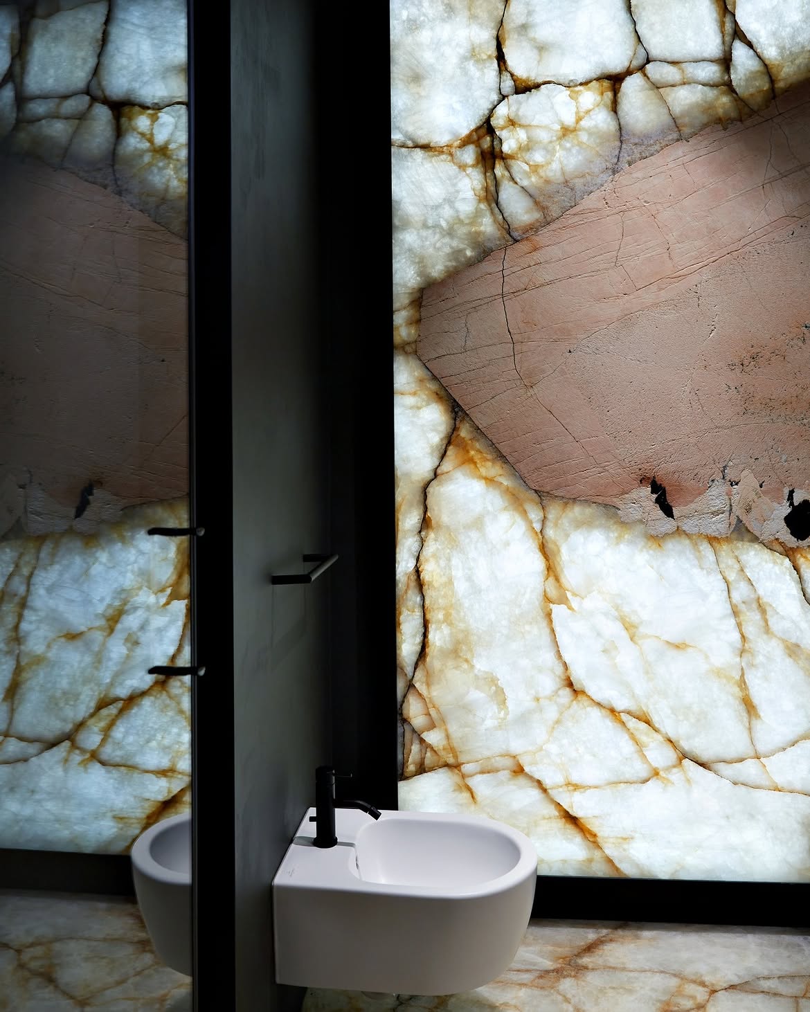 Mur de salle de bains en quartzite Patagonia rétroéclairé : la lumière traverse la plaque à côté du miroir