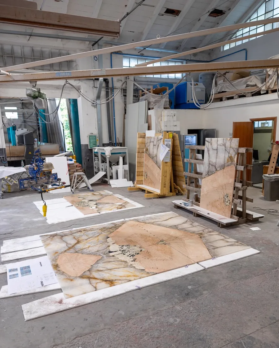 Savoia Marmi atelier tijdens een dry lay: kwartsietpanelen op de vloer en op schragen, met de nestingtekeningen uitgespreid