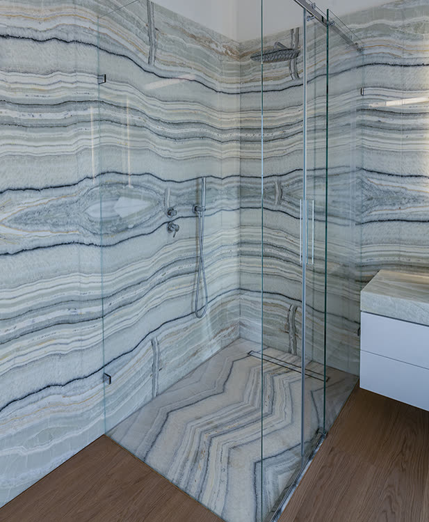 Blick auf die begehbare Dusche mit Glasschiebetür