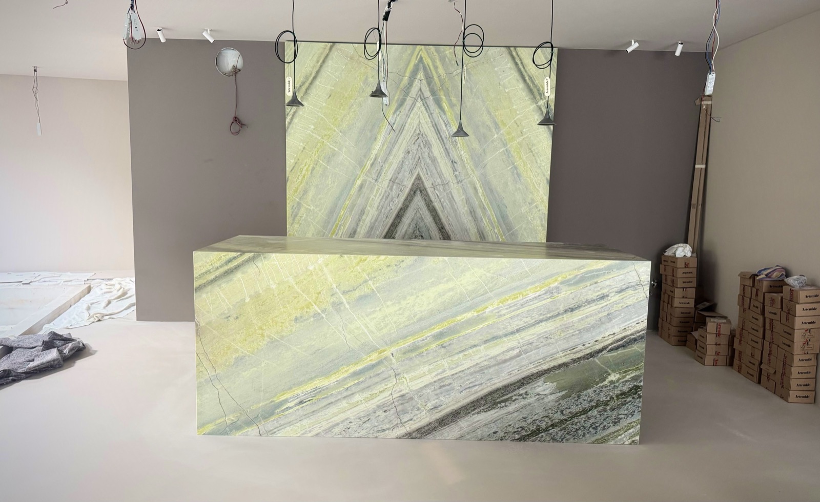 Die Hotellobby ohne Licht: Bookmatch-Wand und Empfangstresen aus Irish Green