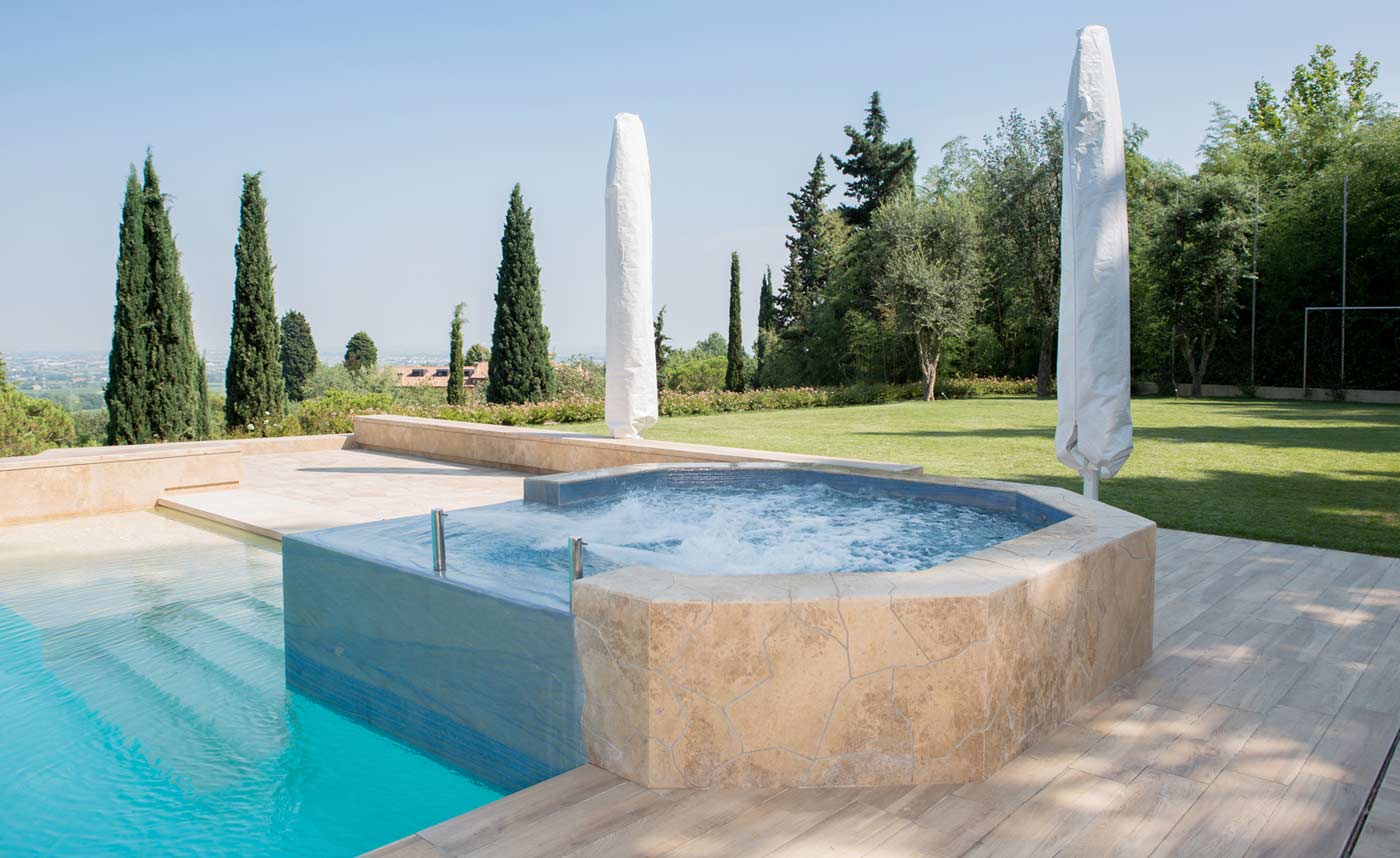Pool clad in solid travertine slabs